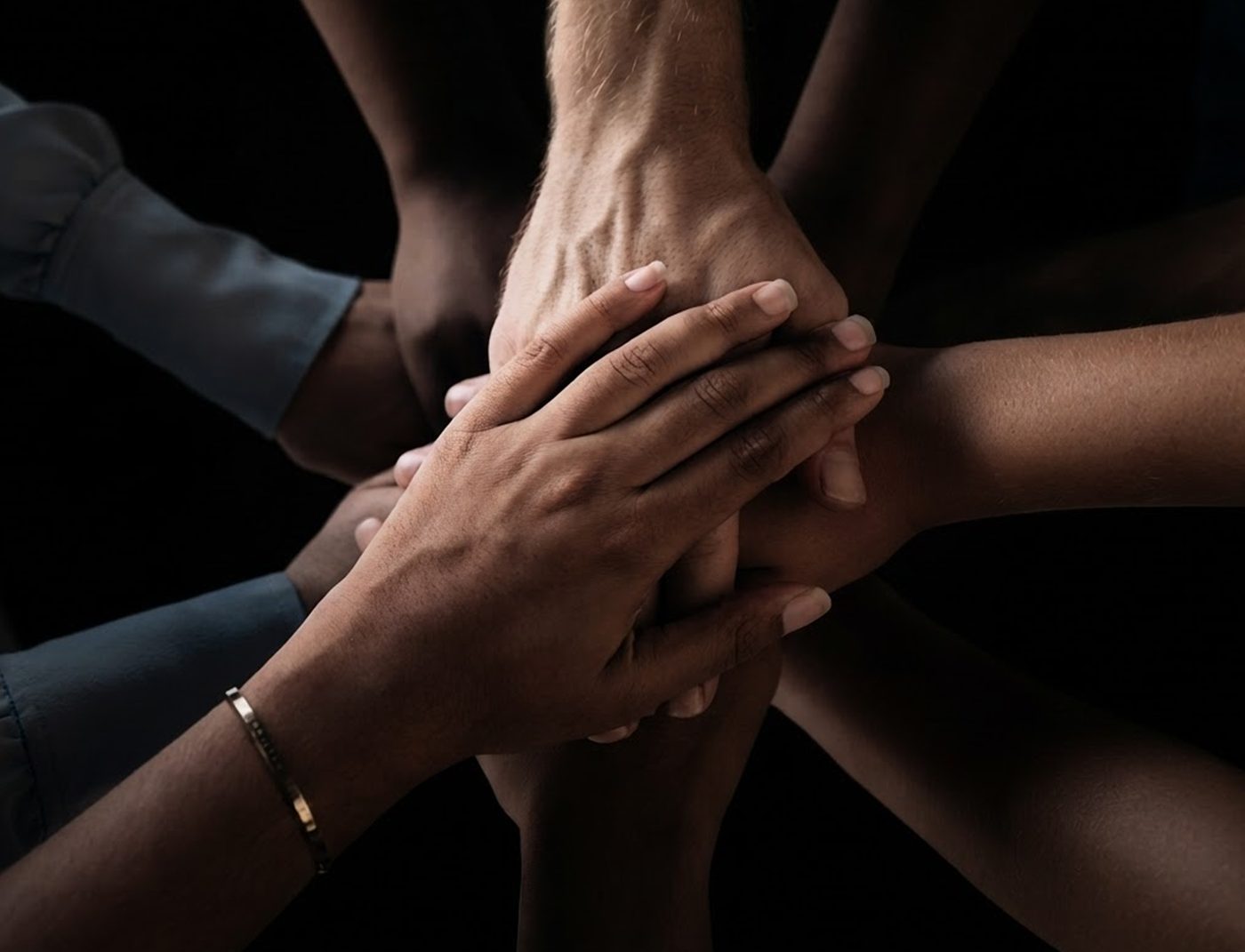 Hands joined together — a team spread across three continents, working as one